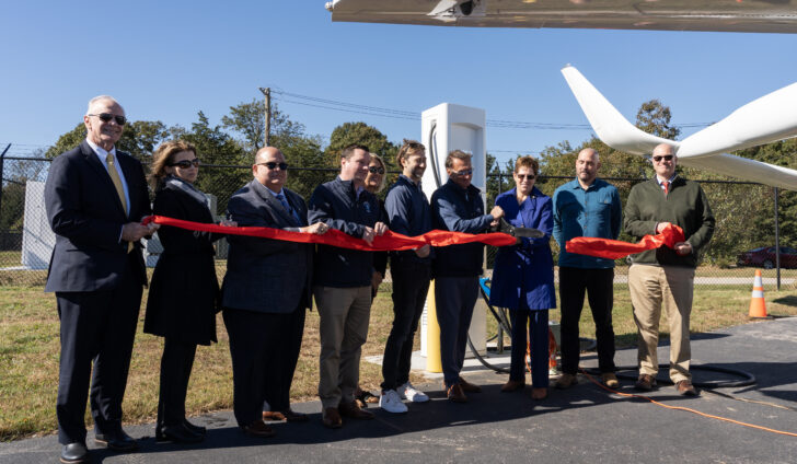 Dignitaries cut a ceremonial ribbon celebrating the commissioning of Shoreline Aviation’s new BETA Technologies-designed electric aircraft charging station, at Marshfield Municipal Airport.
